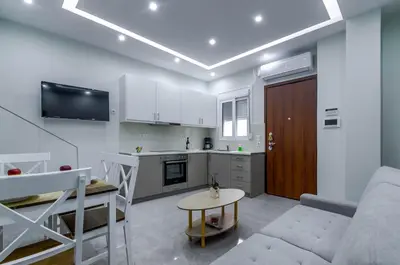 a kitchen and a living room with a couch and a table at Renovated 2BD house close to Pireus port in Piraeus