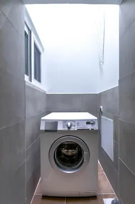 a washer and dryer in a room with a wall at Renovated 2BD house close to Pireus port in Piraeus