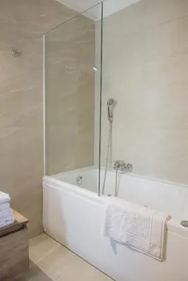 a bathroom with a tub and a glass shower at Palmyra Athens in Athens