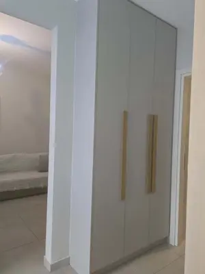 a white cabinet in a room with a bed at A&A Apartment in Piraeus