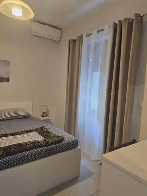 a bedroom with a bed and a window at A&A Apartment in Piraeus