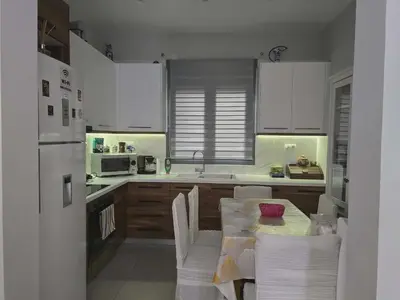 a kitchen with white cabinets and a table with chairs at A&A Apartment in Piraeus