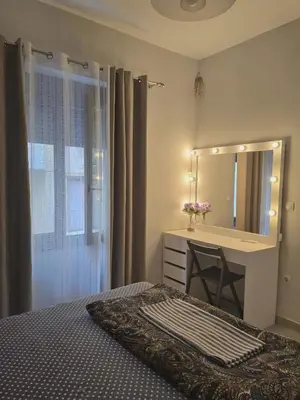 a bedroom with a bed and a vanity with a mirror at A&A Apartment in Piraeus