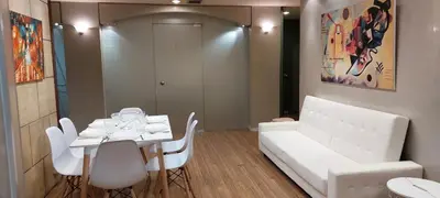 a living room with a white couch and a table and chairs at Deluxe Apartment 12BD 6BATH in Athens