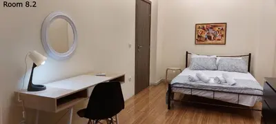a bedroom with a bed with a desk and a mirror at Deluxe Apartment 12BD 6BATH in Athens