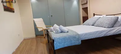 a small bedroom with a bed and a chair at Deluxe Apartment 12BD 6BATH in Athens