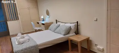 a bedroom with a bed and a table and a chair at Deluxe Apartment 12BD 6BATH in Athens