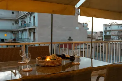 a table with glasses and a bottle of wine on a balcony at AcroLofts M62 in Athens