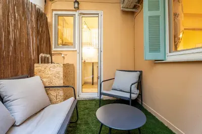 a porch with a couch and a chair and a window at Elegant 2 Bedroom Apartment - near National Museum in Athens