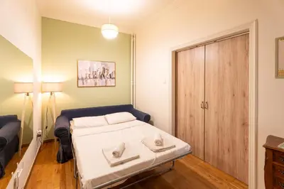 a small bedroom with a bed and a wooden door at Elegant 2 Bedroom Apartment - near National Museum in Athens