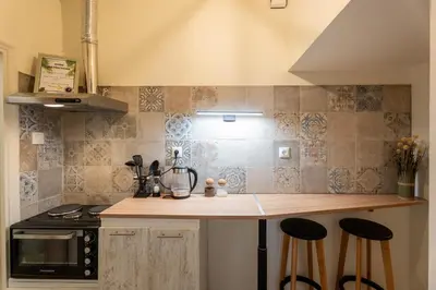 a kitchen with a counter with stools and a microwave at Elegant 2 Bedroom Apartment - near National Museum in Athens