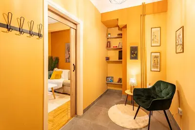 a room with yellow walls and a chair and a bedroom at Renovated 2 Bedroom Apartment in City Centre in Athens