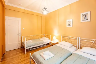 two beds in a room with yellow walls at Renovated 2 Bedroom Apartment in City Centre in Athens