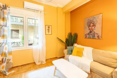 a yellow living room with a couch and a window at Renovated 2 Bedroom Apartment in City Centre in Athens