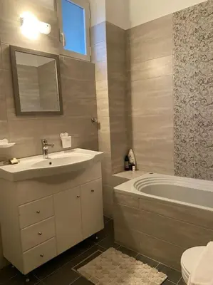 a bathroom with a sink and a tub and a toilet at DS Apartment (semi-basement) in Athens
