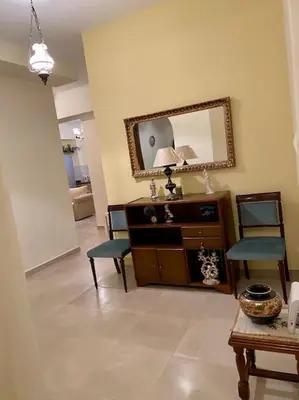 a living room with a mirror and a table and chairs at DS Apartment (semi-basement) in Athens