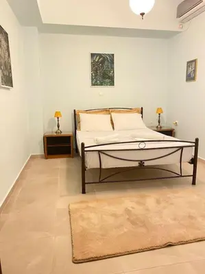 a bedroom with a bed with two tables and a rug at DS Apartment (semi-basement) in Athens
