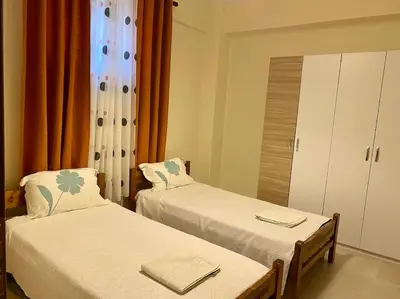 a room with two beds and a cabinet and a window at DS Apartment (semi-basement) in Athens