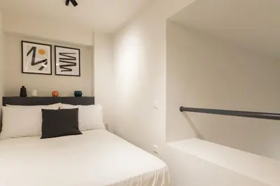 a white bedroom with a bed and a staircase at Voda Luxury Residence #001 - Acropolis View Rooftop in Athens