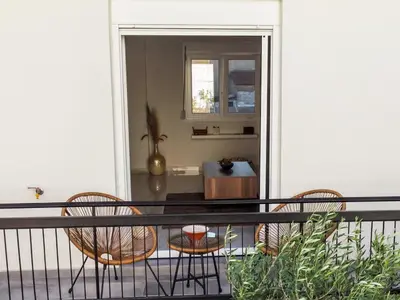 a balcony with two chairs and a table at Zesto spitiko in Piraeus