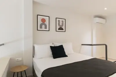a white bedroom with a bed and a stool at Voda Luxury Residence #002 - Acropolis View Rooftop in Athens