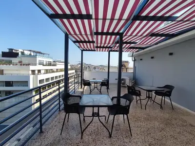 a patio with tables and chairs on a balcony at Voda Luxury Residence #002 - Acropolis View Rooftop in Athens