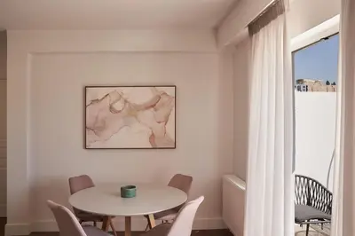 a white dining room with a table and chairs at A Sunkissed retreat under the Acropolis in Athens