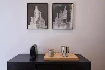 a desk with a phone and two pictures on the wall at A Sunkissed retreat under the Acropolis in Athens