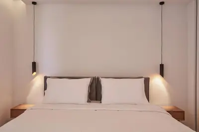 a bed with two pillows and two lights above it at A Sunkissed retreat under the Acropolis in Athens