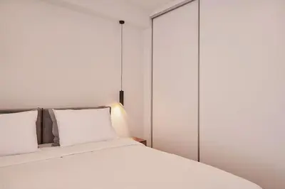 a bedroom with a white bed with glass doors at A Sunkissed retreat under the Acropolis in Athens