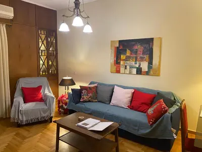 a living room with a blue couch and a table at Tati's Parthenon apt 2bdr with balcony in Athens