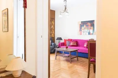 a living room with a pink couch and a table at Tati's Parthenon apt 2bdr with balcony in Athens