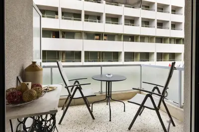 a balcony with a table and chairs and a building at Tati's Parthenon apt 2bdr with balcony in Athens