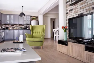 a living room with a television and a green chair at Acropolis Area Large 3BR 2BA Apartment in Athens