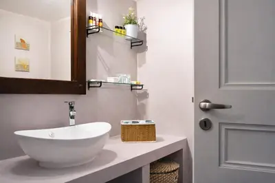 a bathroom with a white bowl sink and a door at Acropolis Area Large 3BR 2BA Apartment in Athens