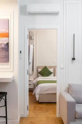 a white room with two beds and a mirror at Lux 2 bedroom apt next to metro in Athens