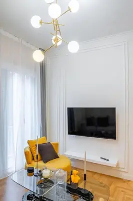 a living room with a yellow chair and a table at Lux 2 bedroom apt next to metro in Athens