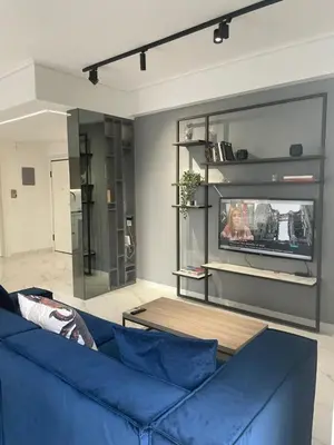 a living room with a blue couch and a tv at Downtown City Apartment in Athens