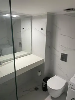 a white bathroom with a toilet and a mirror at Downtown City Apartment in Athens