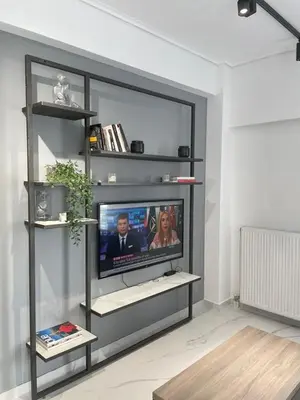 a living room with a flat screen tv on a shelf at Downtown City Apartment in Athens