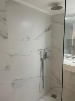 a white bathroom with a shower and a sink at Downtown City Apartment in Athens