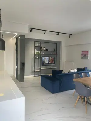 a living room with a blue couch and a tv at Downtown City Apartment in Athens
