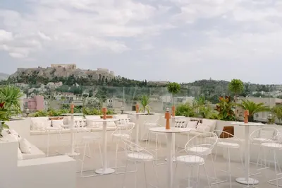 a rooftop patio with tables and chairs and a view ofhens at Apollo Palm Hotel in Athens