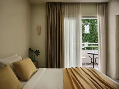 a bedroom with a bed and a window and a table at Apollo Palm Hotel in Athens