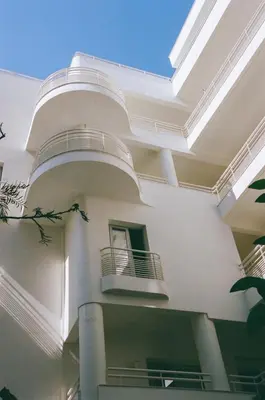 a white building with balconies on the side of it at Apollo Palm Hotel in Athens