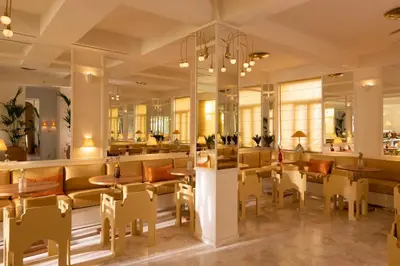 a restaurant with tables and chairs and a bar at Apollo Palm Hotel in Athens