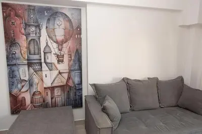 a living room with a couch and a painting on the wall at Fully equipped flat in Piraeus (Erm_C7) in Piraeus