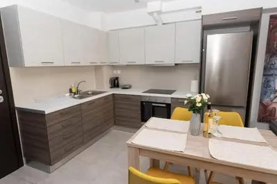 a kitchen with white cabinets and a table with yellow chairs at Fully equipped flat in Piraeus (Erm_C7) in Piraeus