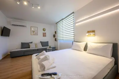 a bedroom with a large white bed and a couch at Nesto Athens Airport Zen in Spáta