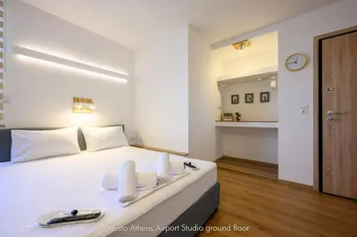 a bedroom with a white bed with towels on it at Nesto Athens Airport Zen in Spáta